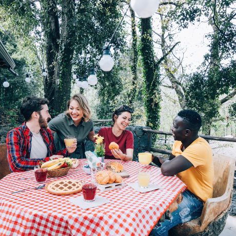 friends have a snack outside in the open air of a mountain farmhouse in the summer